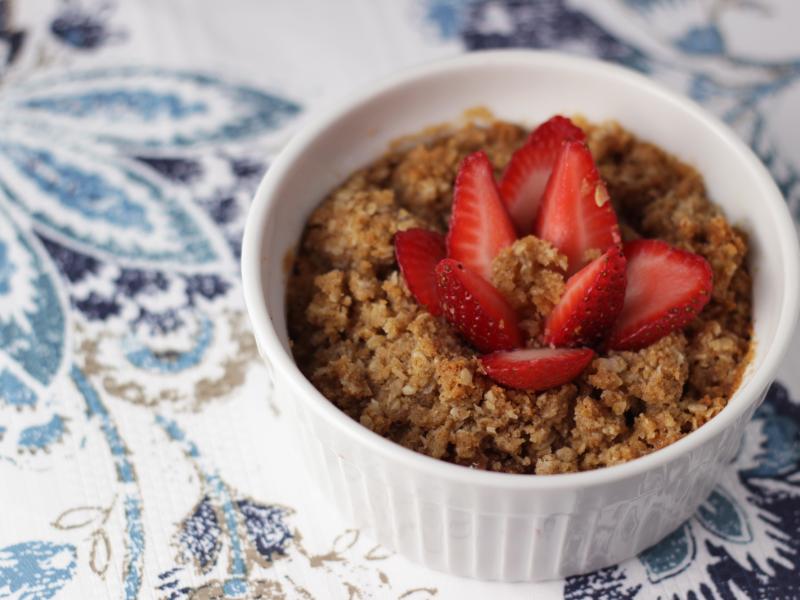 white bowl with cobbler recipe topped with sliced strawberries