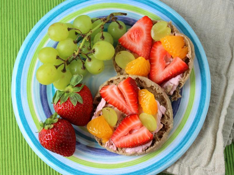 Breakfast Fruit Pizza on a plate with grapes and strawberries on the side