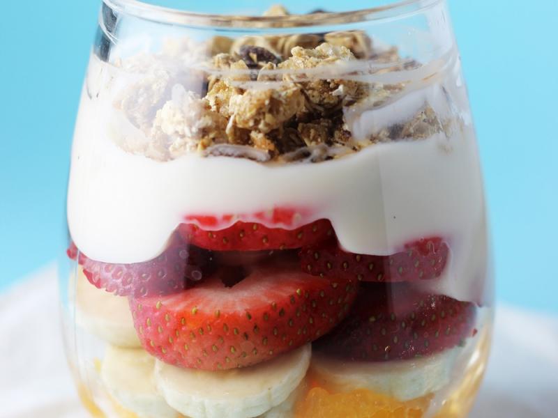 fruit and yogurt breakfast parfait with granola on top