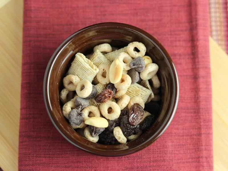 dish of GORP snack mix consisting of cereal, peanuts, chocolate chips and raisins.