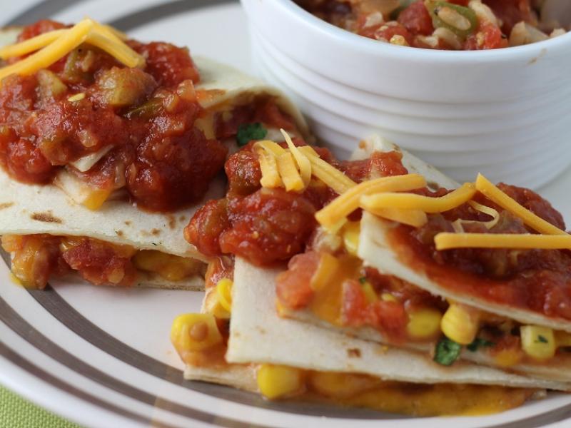 Vegetable Quesadillas topped with salsa and shredded cheese