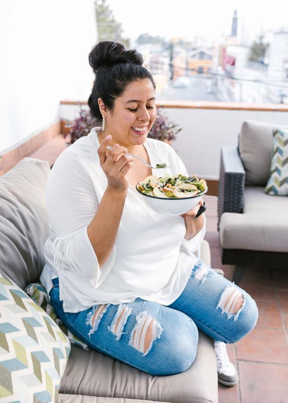 woman on patio eating salad